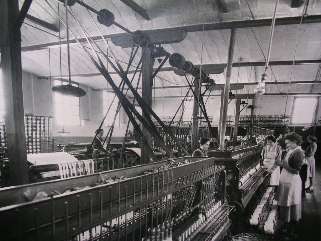 Interior de la fàbrica de Can Xala: detall de les màquines de filar i de les treballadores