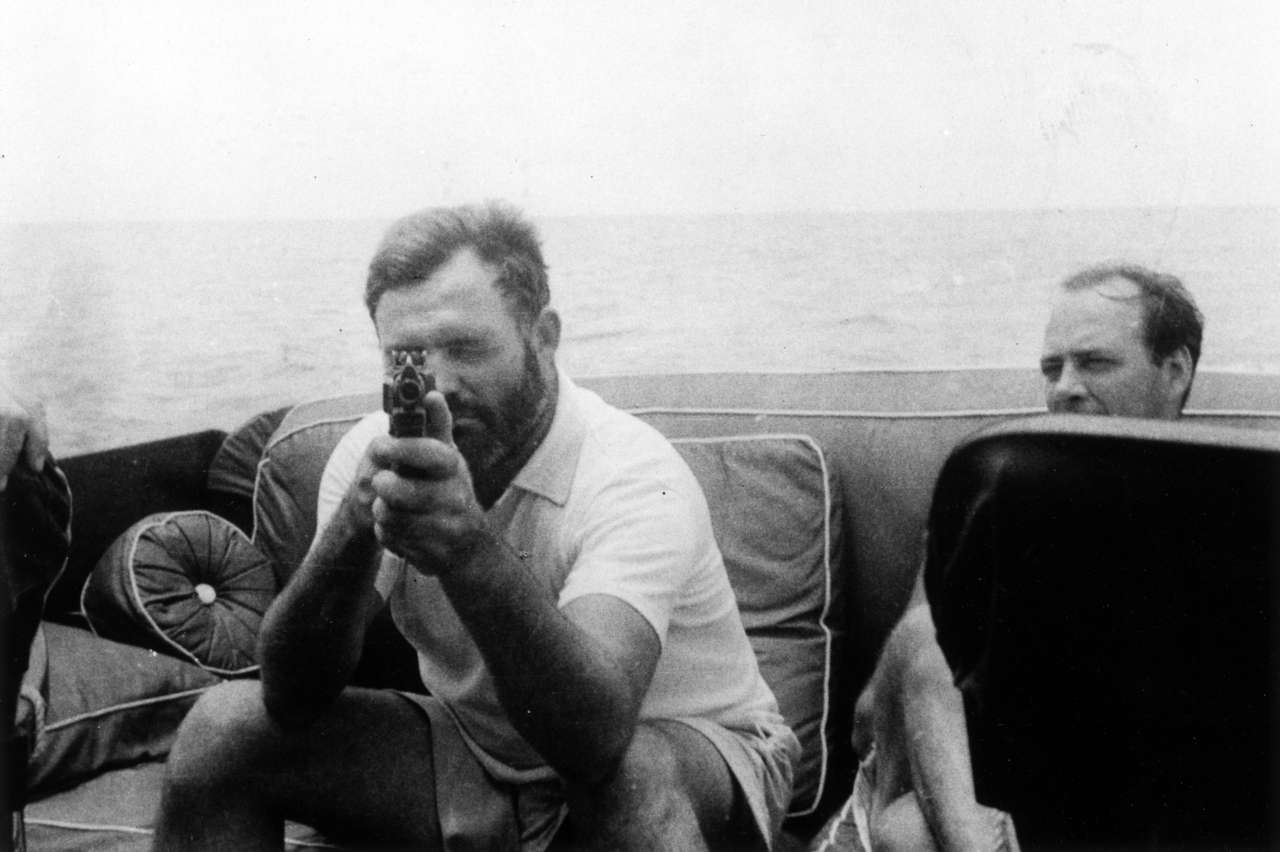 Ernest Hemingway a bord del seu vaixell 'Pilar' apuntant amb una pistola, l'any 1935